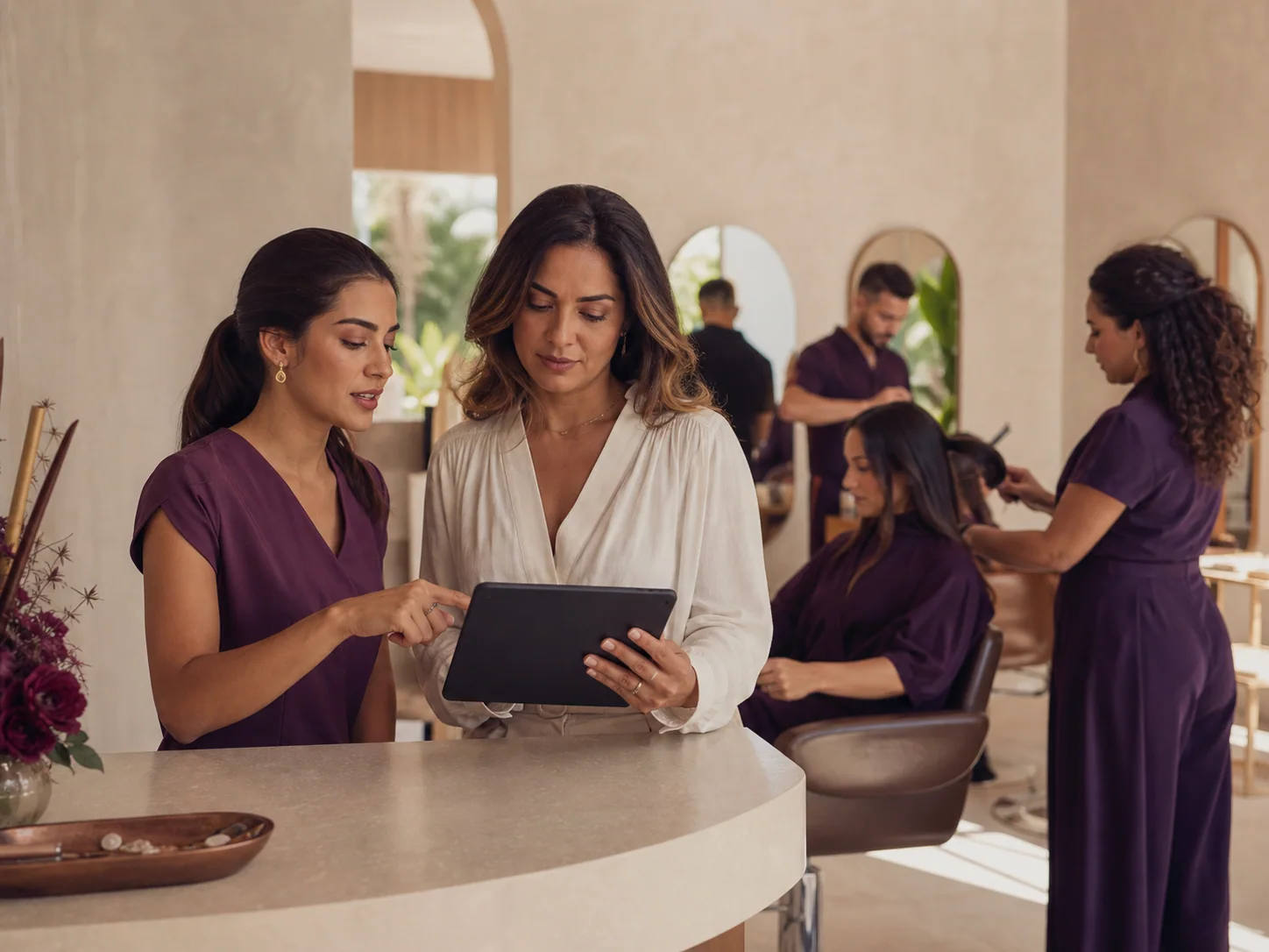Gestora e recepcionista organizando a agenda do salão em um tablet