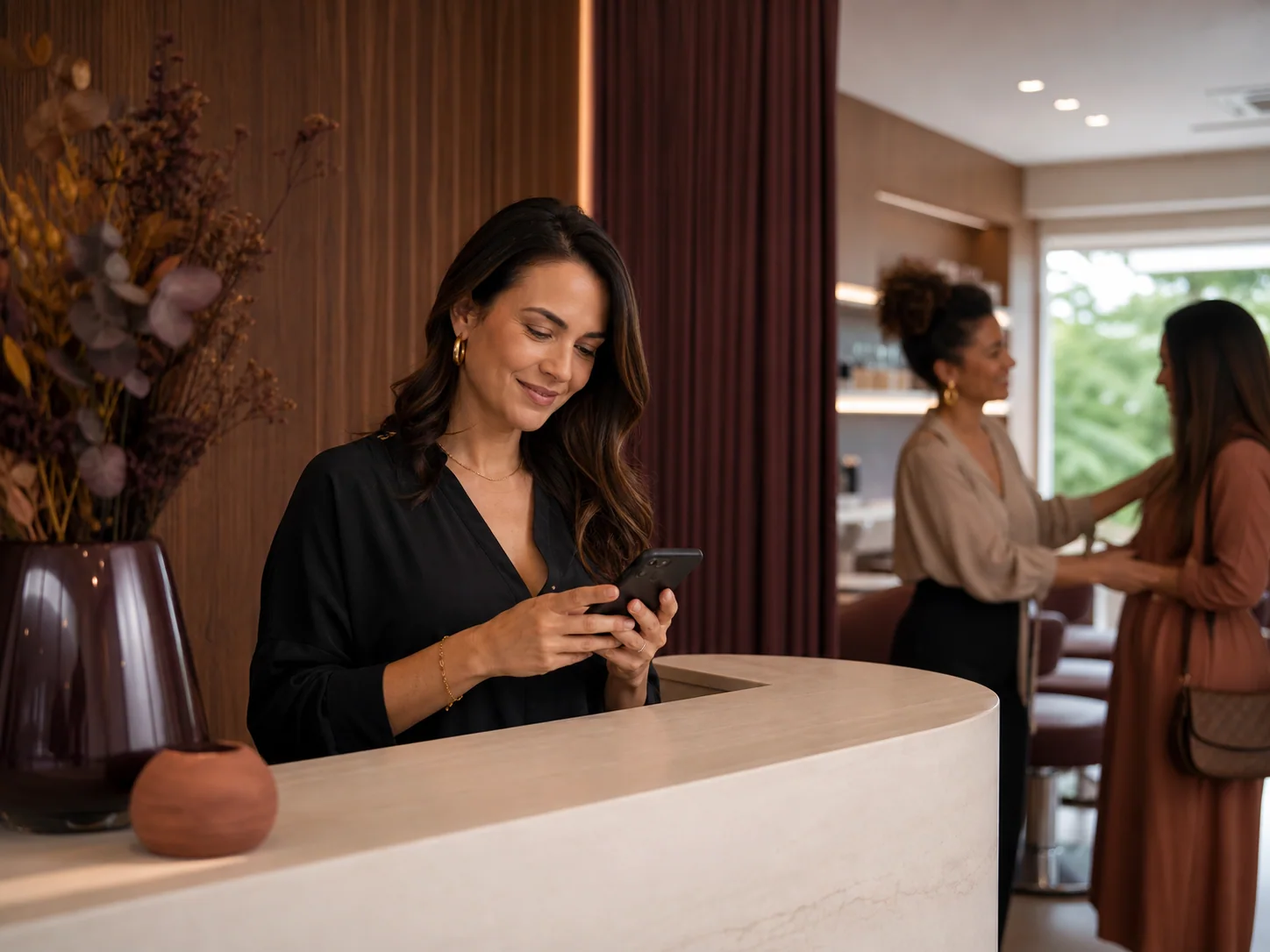 Gestora respondendo clientes pelo celular na recepção do salão
